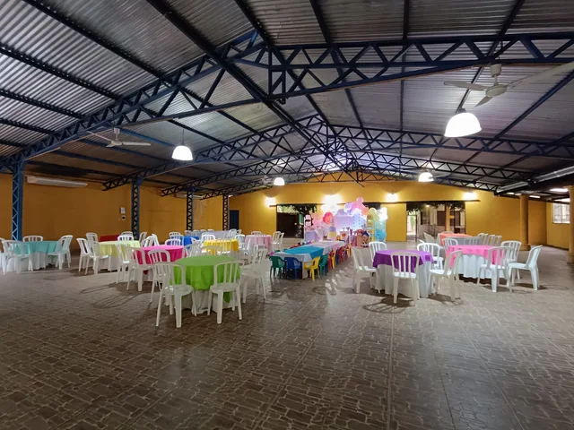 El salón con mesas de colores armadas para un cumpleaños infantil